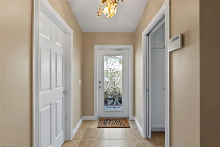 Entryway featuring a chandelier and baseboards