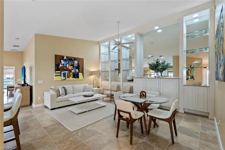 Dining room featuring lofted ceiling, ceiling fan, and stone tile flooring