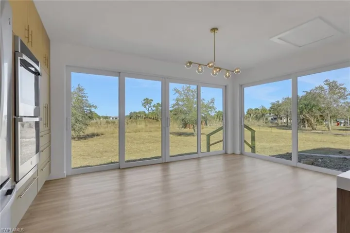Unfurnished sunroom with plenty of natural light and a chandelier