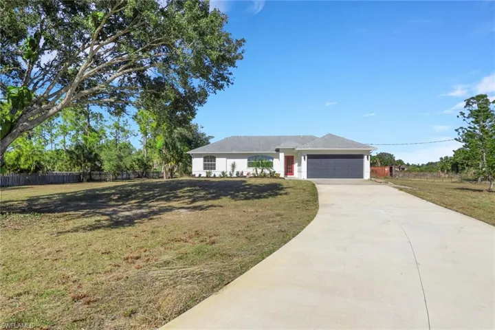 Single story home with concrete driveway and an attached garage