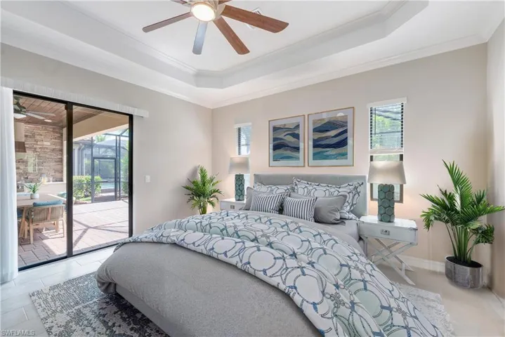 Bedroom featuring access to exterior, ornamental molding, a raised ceiling, and a ceiling fan