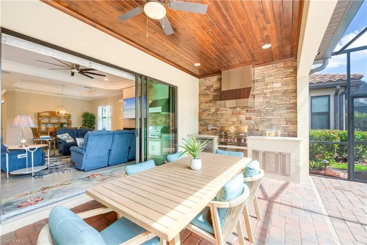 View of patio with a ceiling fan, area for grilling, outdoor lounge area, and glass enclosure