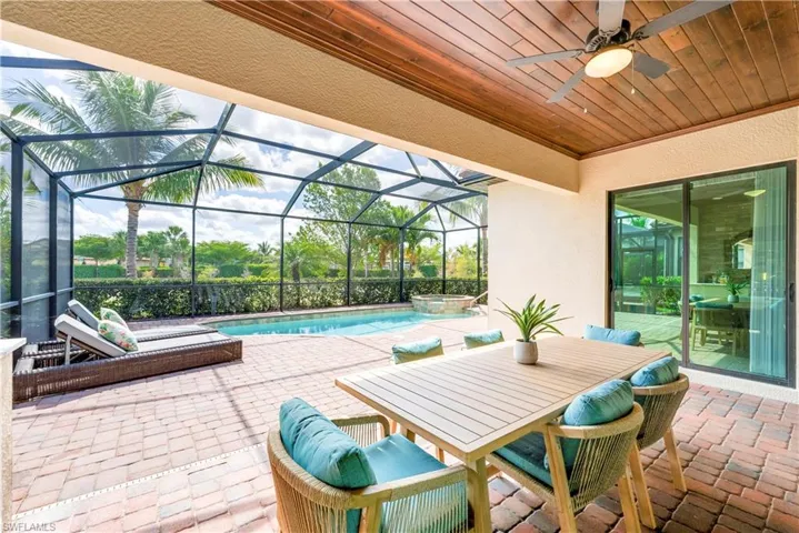 View of patio / terrace featuring ceiling fan, a pool with connected hot tub, and a lanai