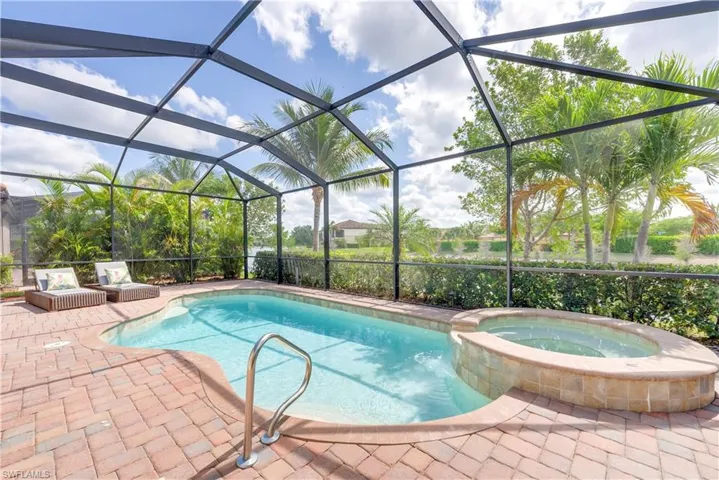 View of swimming pool with a pool with connected hot tub, a patio, and glass enclosure