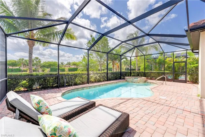 View of pool featuring a patio area, a pool with connected hot tub, and glass enclosure