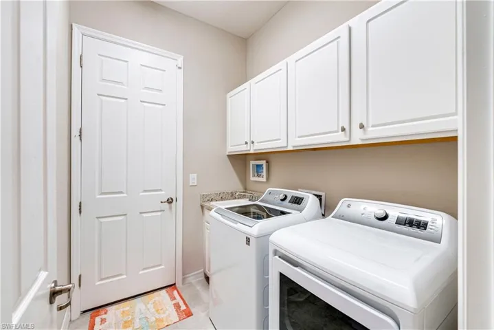 Laundry room featuring cabinet space and washer and clothes dryer