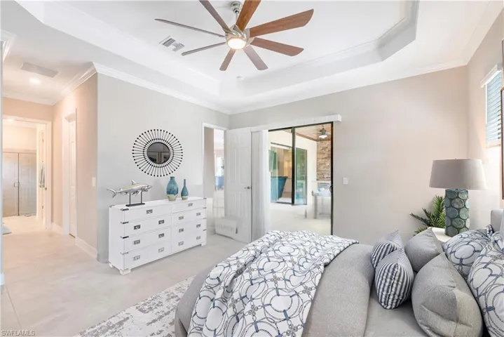 Bedroom featuring access to exterior, a raised ceiling, ornamental molding, and ceiling fan