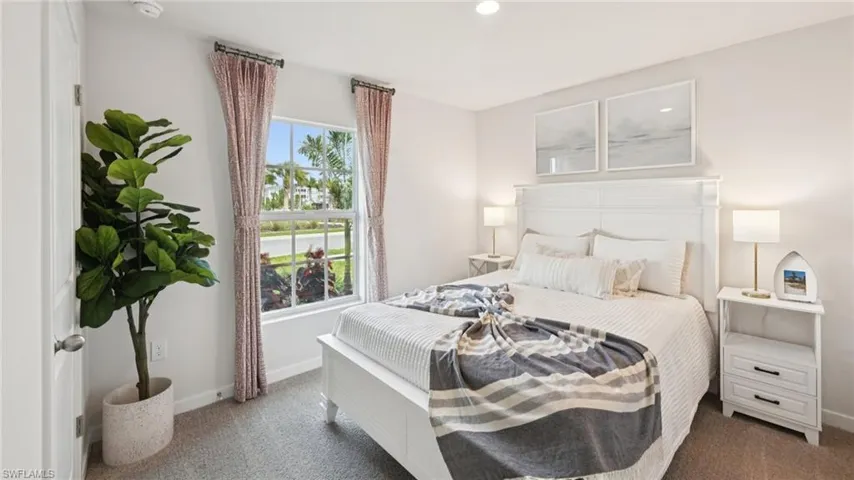 Model Home. This bedroom features light-colored walls, carpeted flooring, and a window with curtains