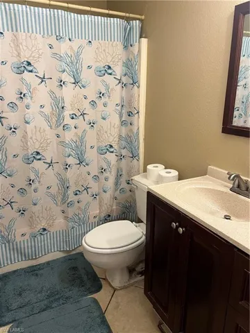 Bathroom with tile flooring, vanity, and toilet