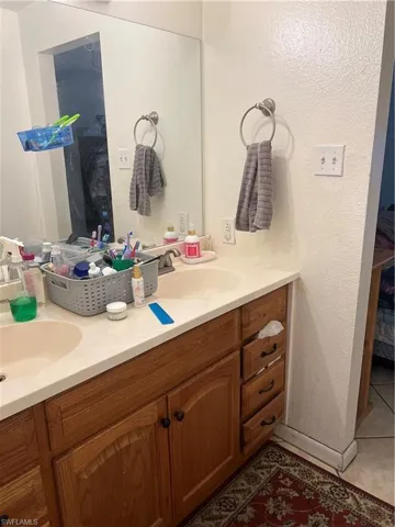 Bathroom featuring tile flooring and double sink vanity