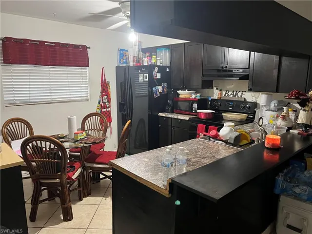 Kitchen featuring ceiling fan, black appliances, and light tile floors