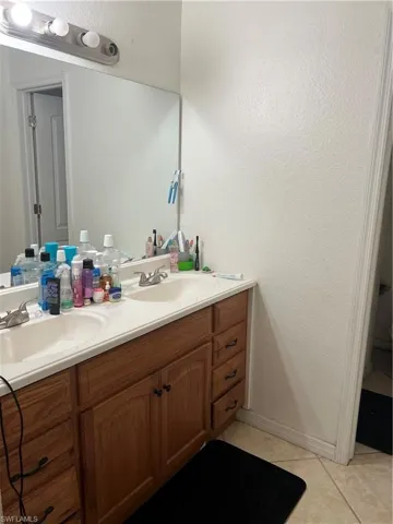 Bathroom featuring tile floors, dual sinks, and oversized vanity