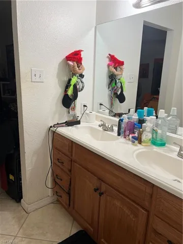 Bathroom with tile floors, large vanity, and double sink