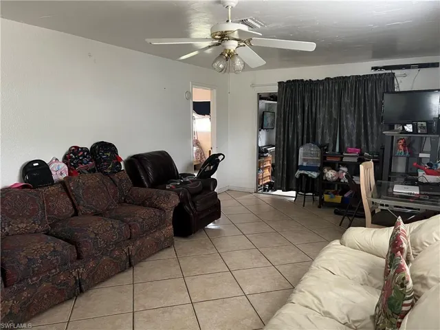 Tiled living room featuring ceiling fan