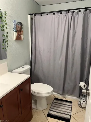 Bathroom featuring tile floors, vanity, and toilet