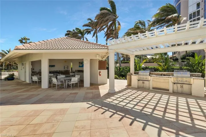 Outdoor grilling area and patio next to pool.