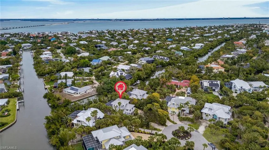 Aerial view of property's location with a large body of water and nearby suburban area
