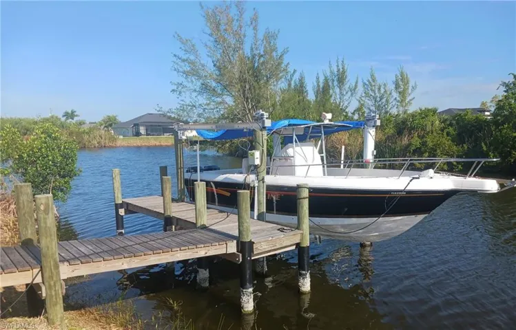 Private boat dock featuring wood decking and a covered boat lift