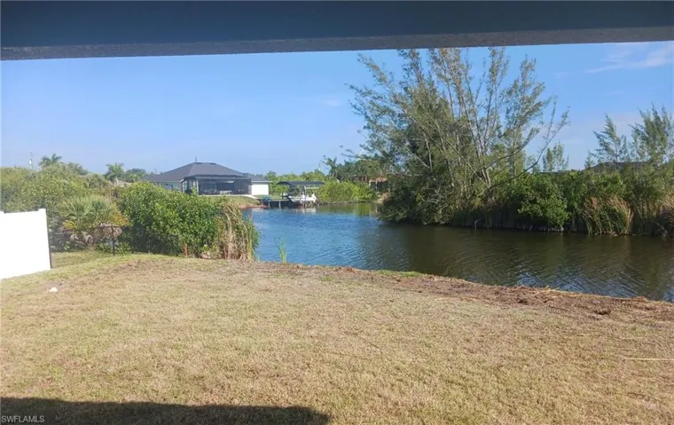 Waterfront property featuring a canal and abundant natural foliage