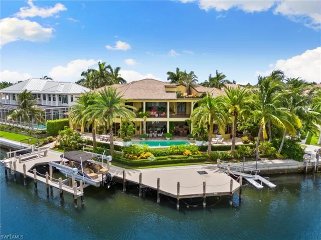 Back of property with a bay view, infinity edge swimming pool, and expansive lanai