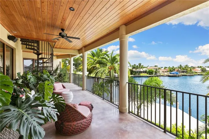 View of patio featuring a balcony, a water view, and ceiling fan