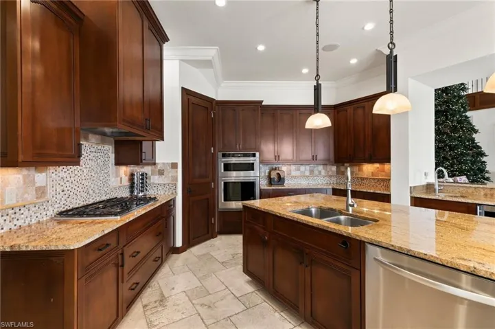 Kitchen with gas cooktop, separate wall oven, under cabinet lighting and stainless steel appliances