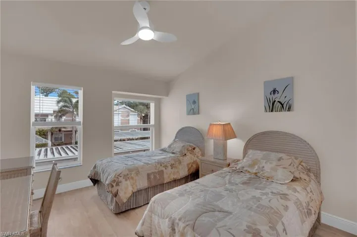 Bedroom featuring vaulted ceiling, light wood-type flooring, and ceiling fan