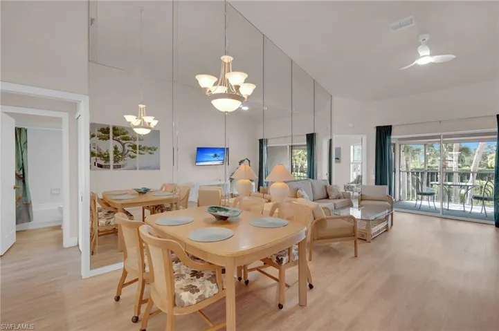 Dining space featuring light wood-style floors, a chandelier, and a towering ceiling