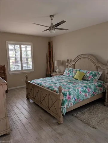 Bedroom with light wood-style floors, ceiling fan, and baseboards