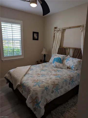 Bedroom featuring wood finished floors, a ceiling fan, and baseboards