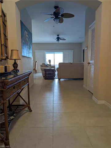 Hallway with light tile patterned flooring and baseboards