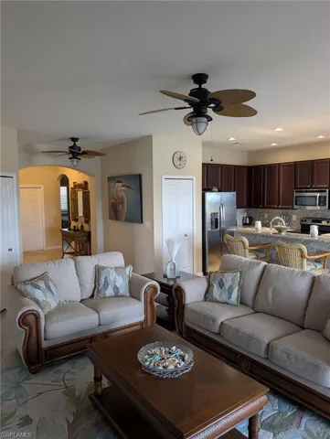 Living area with ceiling fan, recessed lighting, and arched walkways