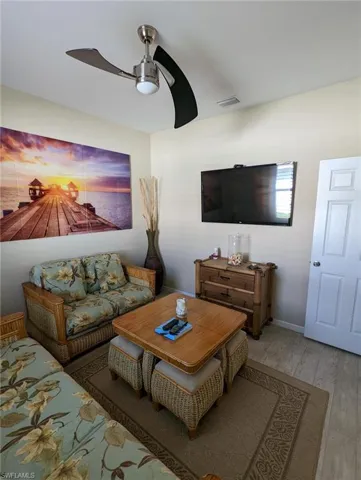 Living area featuring ceiling fan, baseboards, wood finished floors, and visible vents