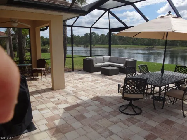 View of patio / terrace featuring an outdoor hangout area, a water view, glass enclosure, outdoor dining area, and a ceiling fan