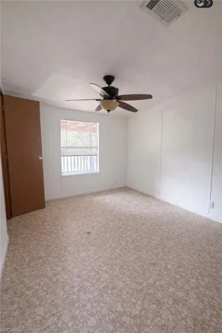 Spare room with light carpet and a ceiling fan