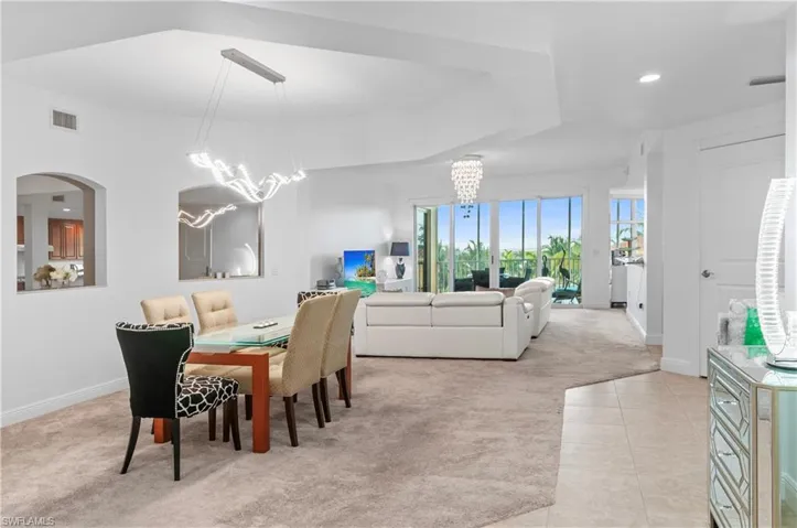 Dining room featuring light carpet, a chandelier, light tile patterned floors, and recessed lighting