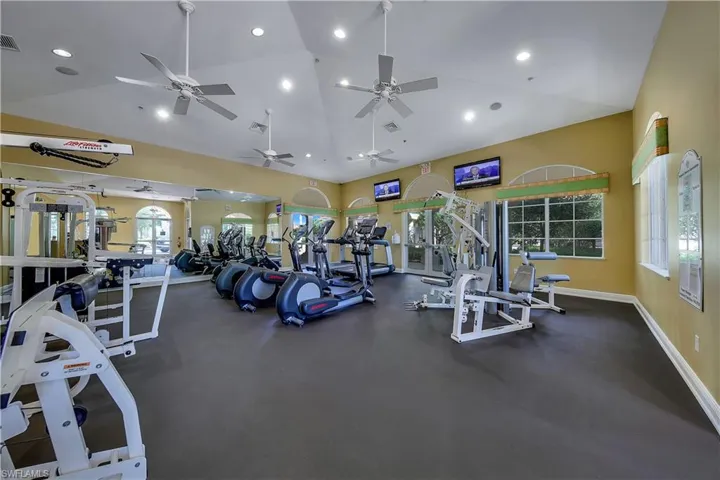 Workout area featuring high vaulted ceiling and recessed lighting