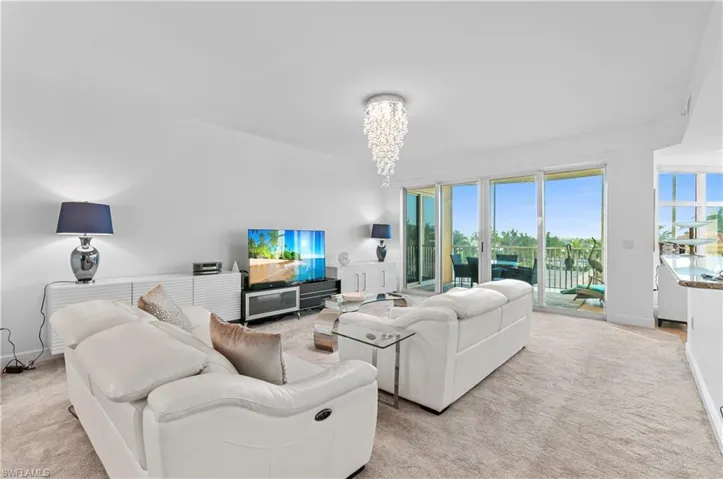 Living area with a chandelier and light colored carpet