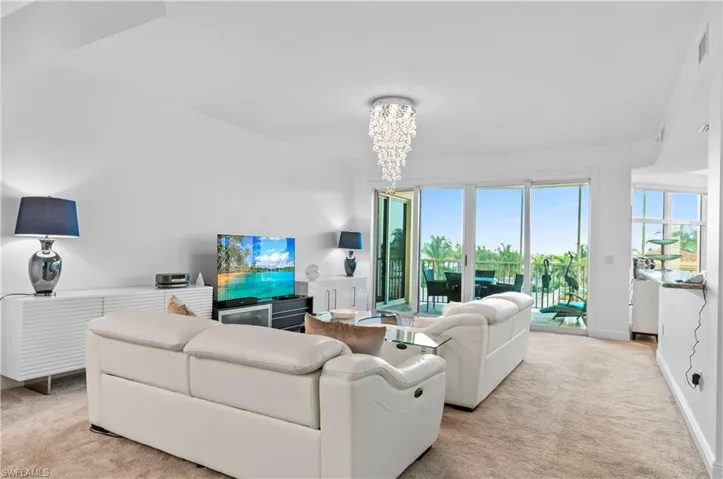 Living room featuring light carpet and a chandelier