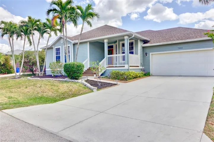 Ranch-style home with driveway, a front lawn, a garage, a porch, and a shingled roof