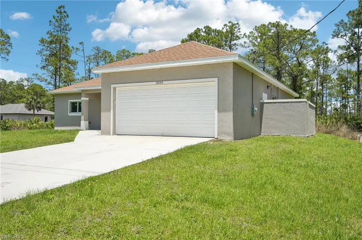 Modern-style home with stucco siding, a garage, concrete driveway, and a front lawn