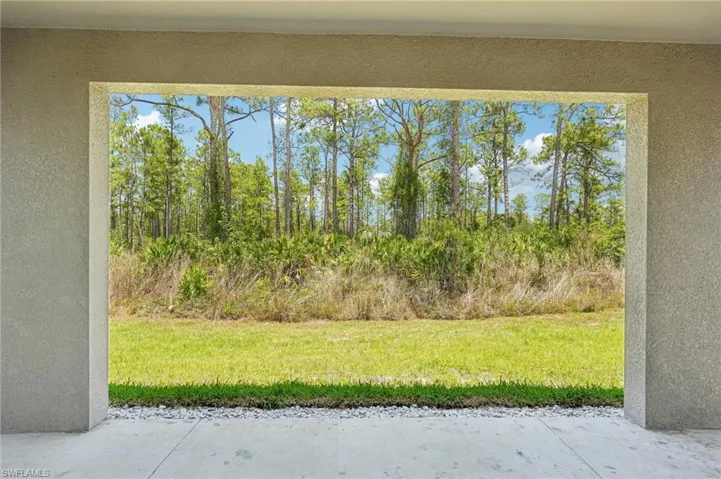 View of grassy yard with a patio area