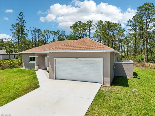 Single story home with stucco siding, concrete driveway, a front yard, and a garage