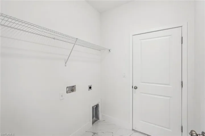 Laundry room featuring hookup for an electric dryer, baseboards, washer hookup, and light marble finish flooring