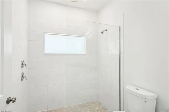 Bathroom featuring toilet and tiled shower