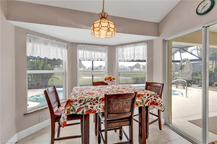 Dining space featuring light tile patterned flooring and vaulted ceiling