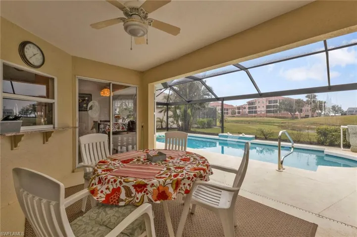 View of pool featuring ceiling fan, glass enclosure, and a patio area