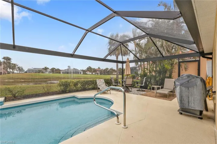 View of swimming pool featuring a patio area and glass enclosure