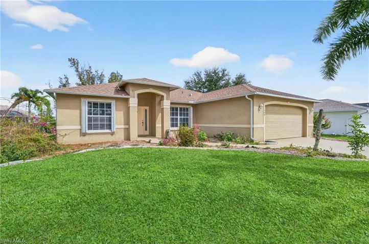 View of front of home with a garage, stucco siding, a front lawn, and concrete driveway