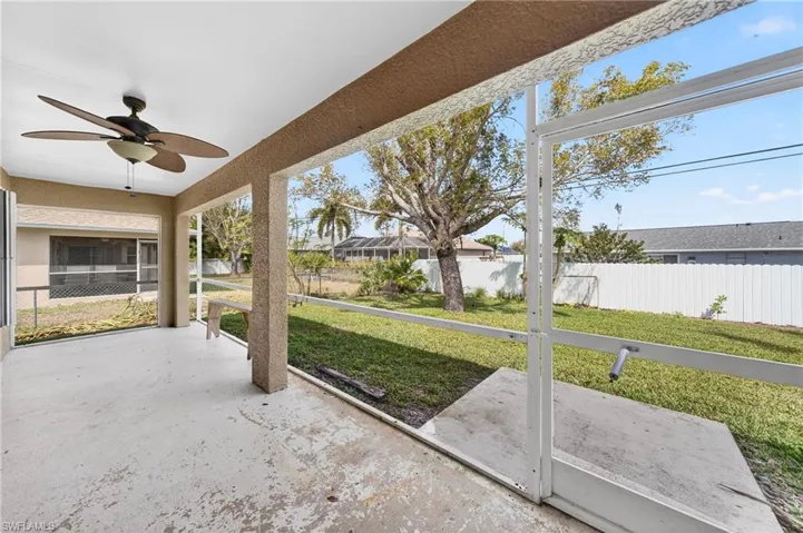 Unfurnished sunroom featuring a ceiling fan and a patio